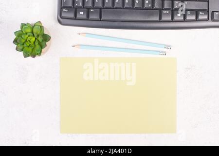 Empty paper with a pen, computer keyboard and a cactus, textured background, brainstorming for new ideas, writing a message, taking a break, home offi Stock Photo