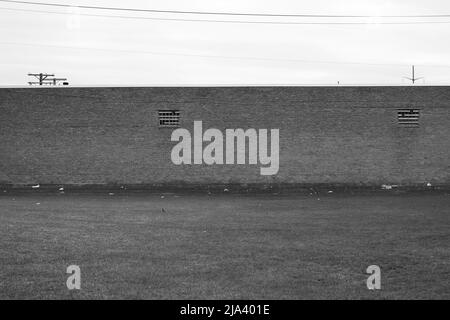 Typical brick wall of a common warehouse in black and white. Stock Photo