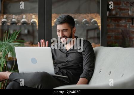 satisfied wine shop owner looking at his laptop screen . Stock Photo