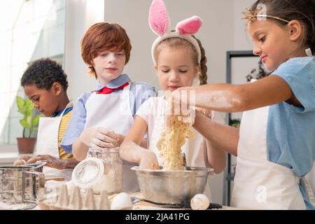 Joyful kids using digital tablet in order to write down menu items for birthday party Stock Photo