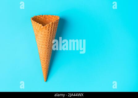 Crispy waffle cone on a blue background. View from above. Stock Photo