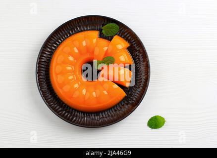 Orange Mango Pudding on Black Plate, Copy Space for Text Stock Photo
