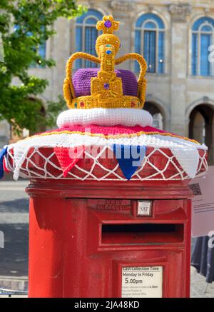 Unfortunate kawaii. Kitsch knitted crown decoration on a post box in Market Place, Abingdon, celebrating the Queen's Platinum Jubilee, Somewhat bad ti Stock Photo