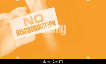 No discrimination words on a card in businessman hand. Social concept against racial and gender discrimination at work. Stock Photo