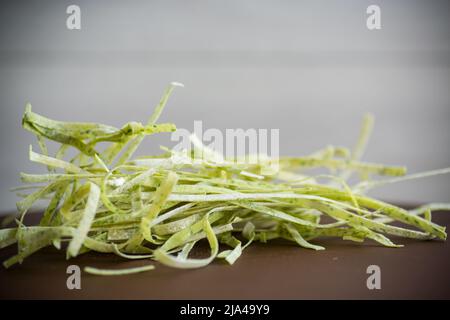 Homemade noodles green with greens on a wooden table Stock Photo