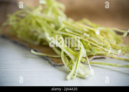 Homemade noodles green with greens on a wooden table Stock Photo