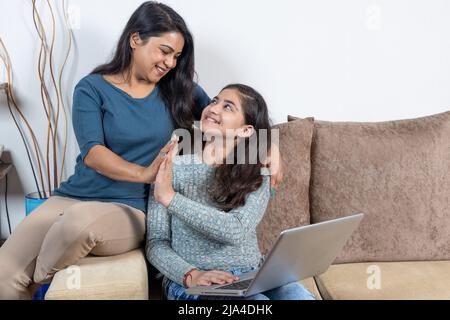 Happy mother and daughter celebrating win with high five Stock Photo