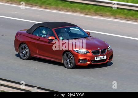 2019 orange BMW 2 SERIES 220I M SPORT 1998cc petrol convertible 2dr sports car; driving on the M6 Motorway, Manchester, UK Stock Photo