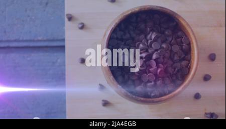 Image of light over chocolate crisps in bowl Stock Photo