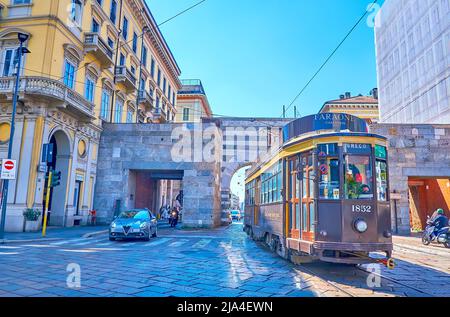 MILAN, ITALY - APRIL 5, 2022: The vintage styled tram at medieval Arch of Porta Nouva gates, on April 5 in Milan, Italy Stock Photo