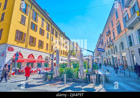 MILAN, ITALY - APRIL 5, 2022: Pedestrian Corso Como street attracts locals and tourists to one of its atmospheric outdoor restaurants, on April 5 in M Stock Photo