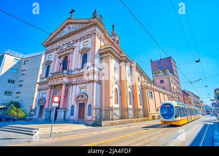 MILAN, ITALY - APRIL 5, 2022: The retro styled tram rides at the monumental Basilica of St.Antony of Padua, on April 5 in Milan, Italy Stock Photo