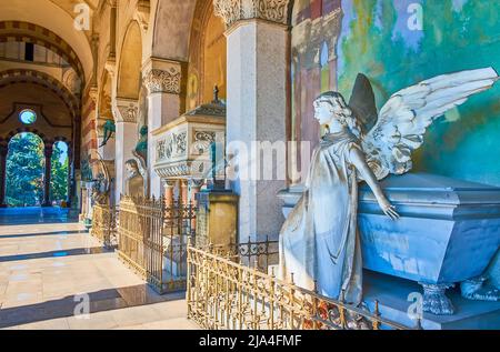 MILAN, ITALY - APRIL 5, 2022: The line of the tombs with sculptures in the loggia of Monumental Cemetery, on April 5 in Milan, Italy Stock Photo