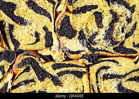 Unusual pumpkin marbled (tiger print) bread with cuttlefish ink, braided on a light background. Useful home baking. Texture laid out from slices of br Stock Photo