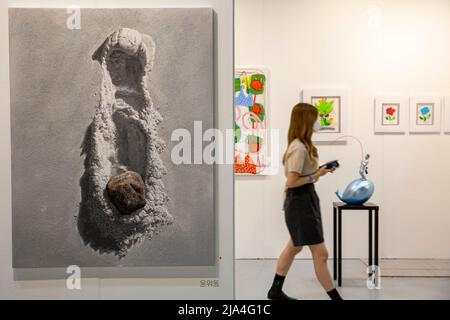 Seoul, South Korea. 27th May, 2022. A visitor passes behind an artwork at an exhibition of the Plastic Art Seoul in Seoul, South Korea, May 27, 2022. The exhibition kicked off on Thursday will last till May 29. Credit: Wang Yiliang/Xinhua/Alamy Live News Stock Photo