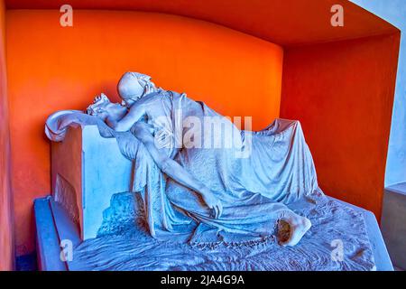 MILAN, ITALY - APRIL 5, 2022: Imressive tombstone with a sculpture of a couple in Famedio of Memorial Cemetery, on April 5 in Milan, Italy Stock Photo