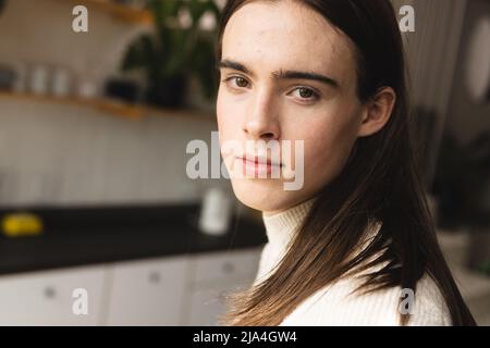 Close up portrait of non-binary trans woman in the kitchen at home Stock Photo