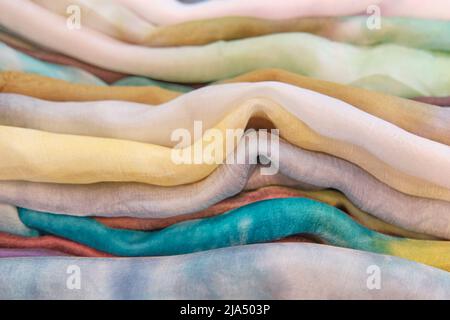 Texture of colorful uzbek silk soft fabrics folded as abstract striped textile background. Stock Photo