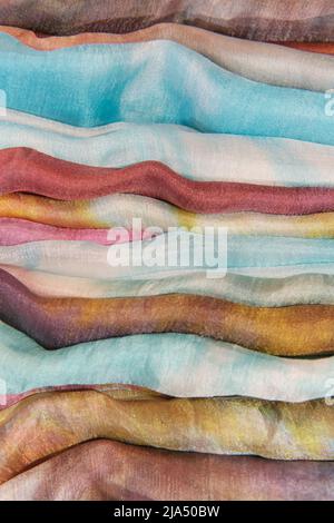 Multi-colored uzbek silk fabrics stacked. Stock Photo