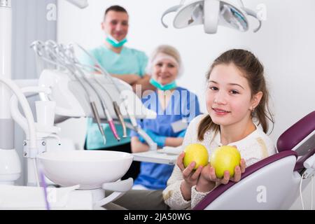 Happy girl with apples in dental clinic Stock Photo