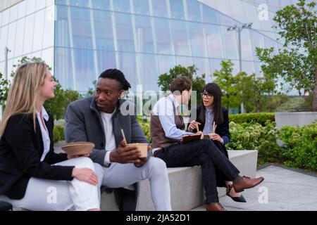 Two coworkers sharing food in financial district Stock Photo
