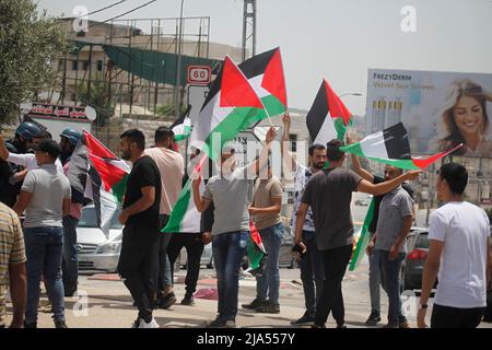 Nablus, Palestine. 27th May, 2022. Palestinians wave Palestinian flags during a protest against the removal of Palestinian flags by Jewish settlers, in the town of Hawara, south of the city of Nablus in the occupied West Bank. Credit: SOPA Images Limited/Alamy Live News Stock Photo