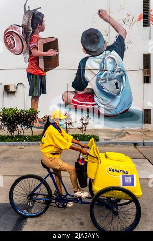 An Ice Cream Seller Passes By A Colourful Wall Mural In The Barranco District, Lima, Peru. Stock Photo