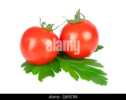 Two cherry tomatoes on a green parsley leaf isolated on white Stock Photo