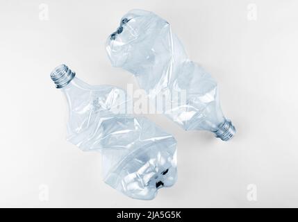 Two crumpled plastic water bottles on grey background Stock Photo