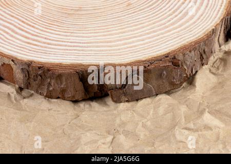Tree slice,slab, cookie with annual rings on rusticcrampledcraftpaper close up Stock Photo