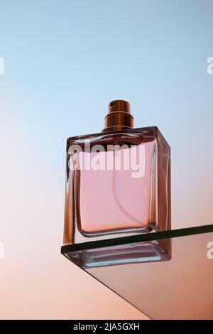 Bottom view of one spray bottle of perfume stands on a glass table Stock Photo