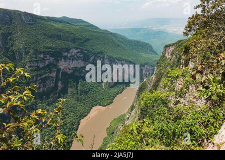 a muddy Grijalva river flows through the Sumidero Canyon, a deep natural canyon popular with tourists in Chiapas state, Mexico Stock Photo