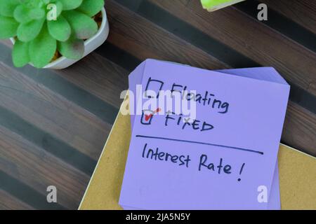 Concept of Someone choose fixed interest rate write on a sticky notes isolated on Wooden Table. Stock Photo