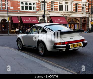 London, Greater London, England, May 14 2022: White Porsche 911 Carrera in Sloane Square Chelsea with the French restaurant Colbert in the background. Stock Photo