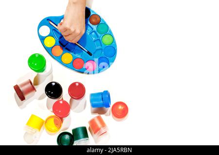 Jars with gouache multicolored paint, palette, brush. Top view.Flat lay. Stock Photo