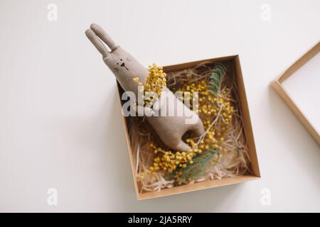 Funny handmade bunny rabbit toy with flowers in a gift box Stock Photo