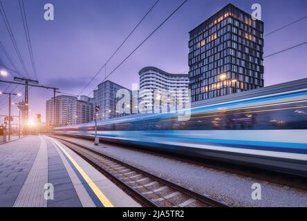 High speed train in motion on the railway station at sunset Stock Photo