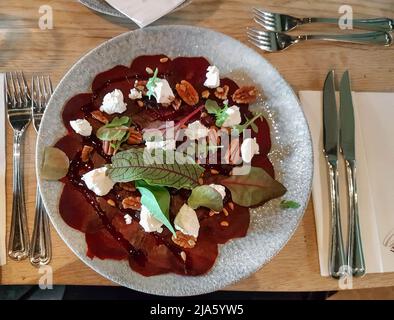 Carpaccio with truffle mayonaisse and Parmesan cheese with cutlery next to it served on a luxury plate in a restaurant in the Netherlands Stock Photo