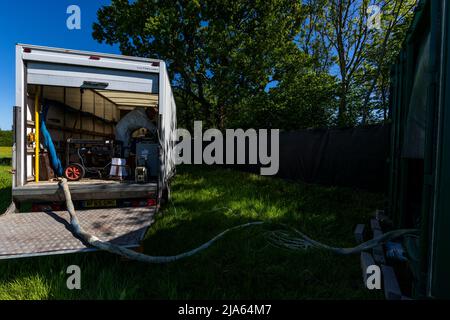 A workman sprays a shipping container ceiling with Grapho Therm to prevent the build up of condensation. Stock Photo