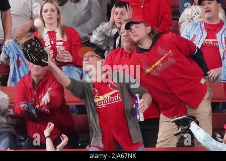 St. Louis Cardinals fans in the center field bleachers reach for a