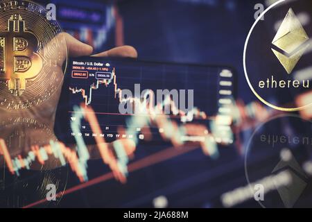 Gold bitcoins on smartfone with Candle stick graph chart and digital background. Stock Photo