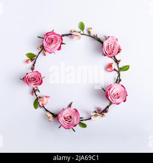 Round frame made of red roses on a light gray background. Minimal abstract concept. Square with copy space. Top view, flat lay Stock Photo