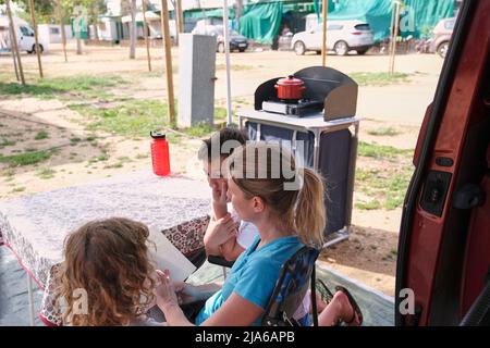 Mother reading book with children on vacation Stock Photo