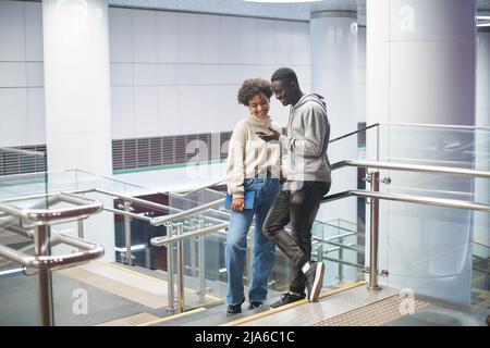 couple of students reading an email while standing in the subway Stock Photo