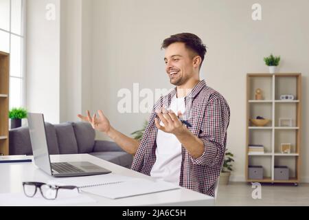 Male freelancer or student working on laptop has finally found information he needs on Internet Stock Photo