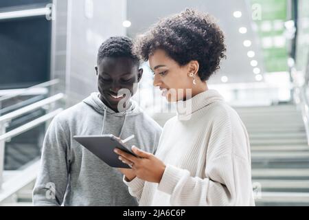 young couple of tourists using a digital tablet to search for a route. Stock Photo
