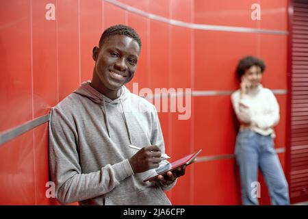 smiling guy with a digital tablet looking at the camera . Stock Photo