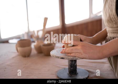 close-up female hands of a potter making a cup in traditional style. Hands sculpt dishes from clay, Stock Photo