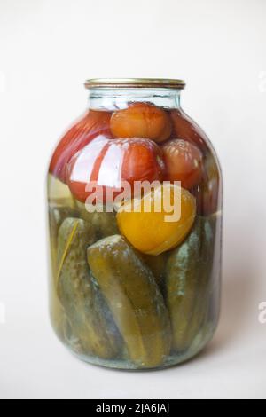 spoiled can of vegetable seaming. Glass jar with homemade pickled tomatos and cucumbers with white fungus and mold Stock Photo