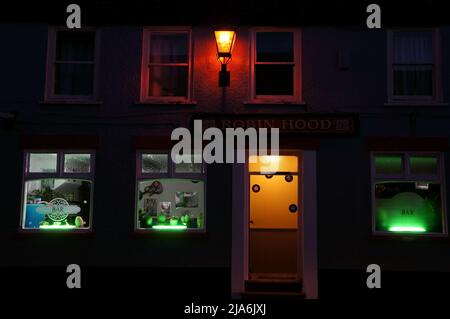 The Robin Hood pub with windows lit up at night Stock Photo
